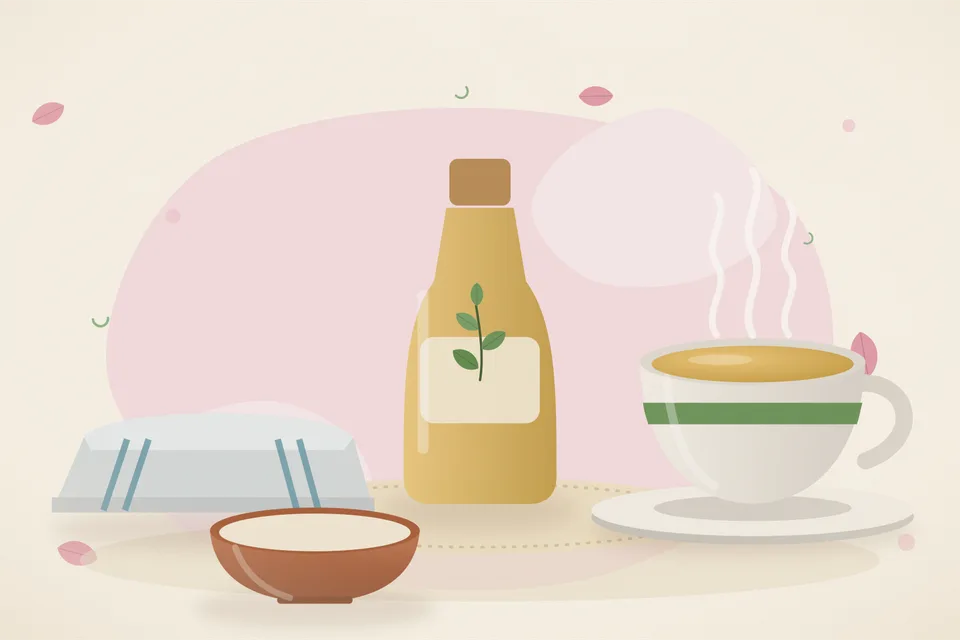 A folded cotton cloth, a small bowl of castor oil, and a wooden spoon arranged on a kitchen tray in warm light.