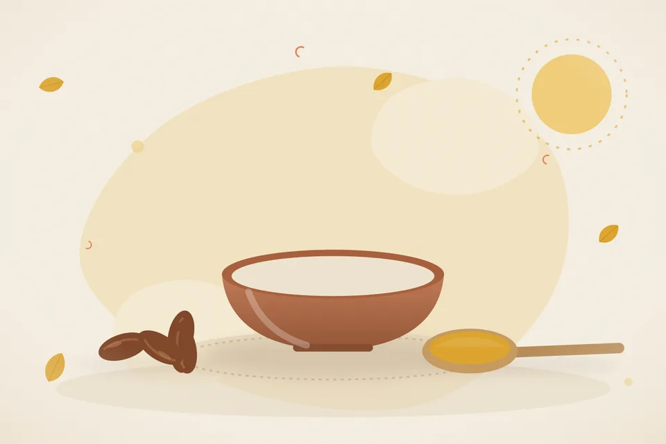 Two soft dates and a few drops of ghee in a small brass bowl on a wooden board
