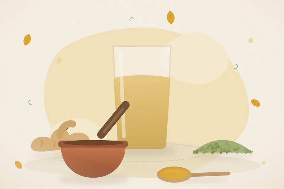 Dry ginger pieces, fennel seeds and a brass cup of pale tea on a wooden board