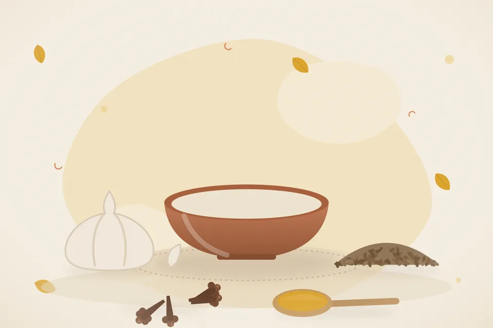 Two garlic cloves, cumin seeds and a small bowl of ghee on a wooden board