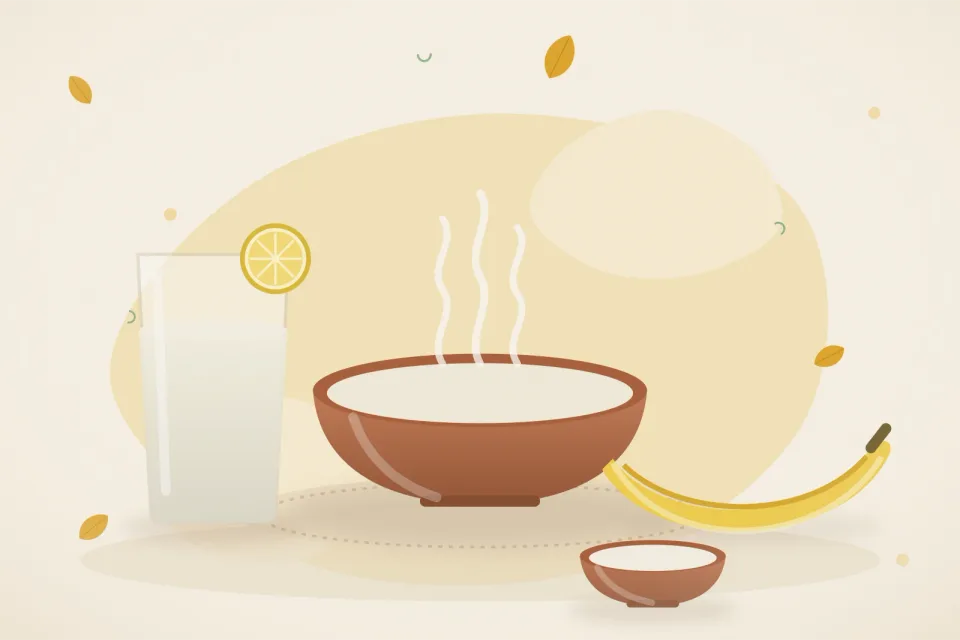 A glass of ORS with lemon, a bowl of rice kanji, bananas and a small bowl of curd on a turmeric-yellow background