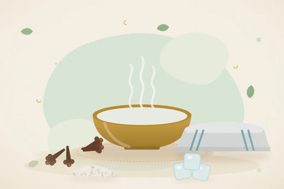 Soft cloth compress with ice cubes, a heap of cloves and a bowl of warm salt water